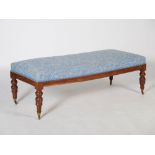 A 19th century mahogany rectangular stool, the blue foliate upholstered top raised on four tapered