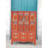 A Chinese red lacquer marriage cabinet, with four panelled cupboard doors decorated with panels of