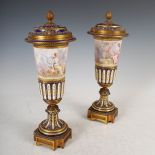 A pair of late 19th century ormolu mounted blue ground porcelain urns and covers, with hand