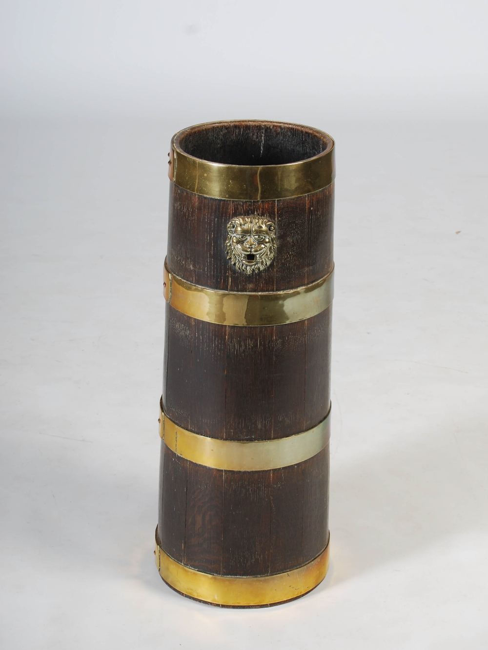 A 19th century oak and brass bound barrel shaped stick stand, with lion mask terminals and four