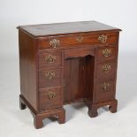 A George III mahogany knee hole desk, the rectangular top with moulded edge above a cockbeaded