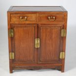 A Chinese dark wood side cabinet, late Qing Dynasty, the panelled rectangular top above two frieze