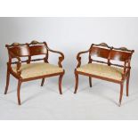 A pair of painted satinwood double chair back Regency style settles, the concave rectangular backs
