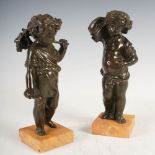 A pair of 19th century bronze putti emblematic of the harvest, mounted on square shaped yellow
