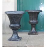 A pair of 20th century black and white veined marble urns, formed in two sections, resting on square