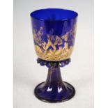 A late 19th century Bristol blue glass goblet, decorated with a battle scene of gladiators, on a