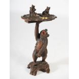 A late 19th/early 20th century Black Forest smokers stand, the upper section carved with a small