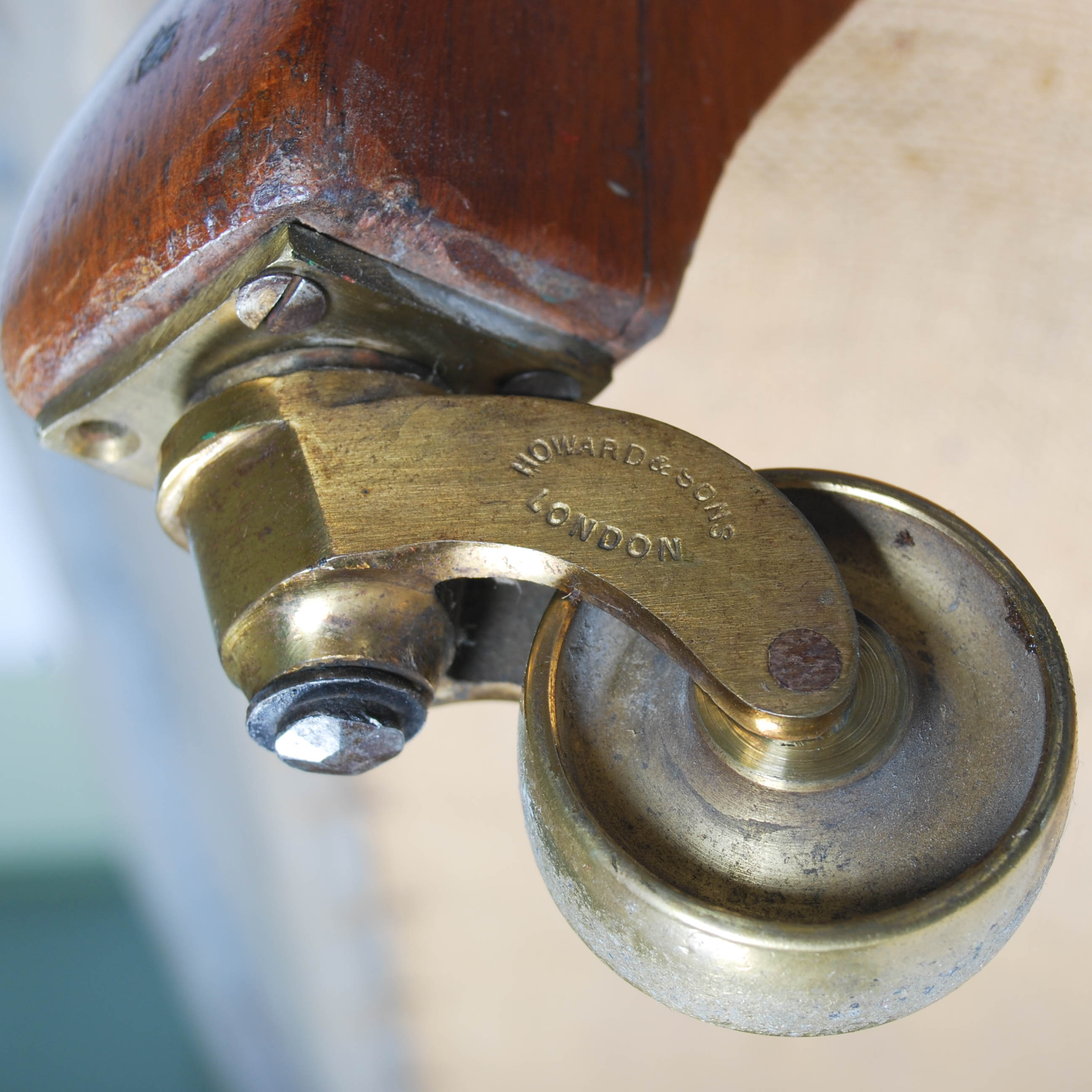 A Howard & Sons walnut Chesterfield sofa, raised on turned supports with brass cups and castors, - Image 4 of 6