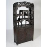 A Chinese dark wood display cabinet, Qing Dynasty, the upper section with six open shelves within