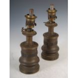 A pair of late 19th century bronze oil lamps, the cylindrical bodies cast with a scroll frieze