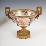 An ormolu mounted Japanese Imari bowl, Meiji Period, the bowl decorated with panels of peony on a