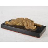 A late 19th century gilt bronze desk weight, in the form of a bear lying on its tummy, mounted on