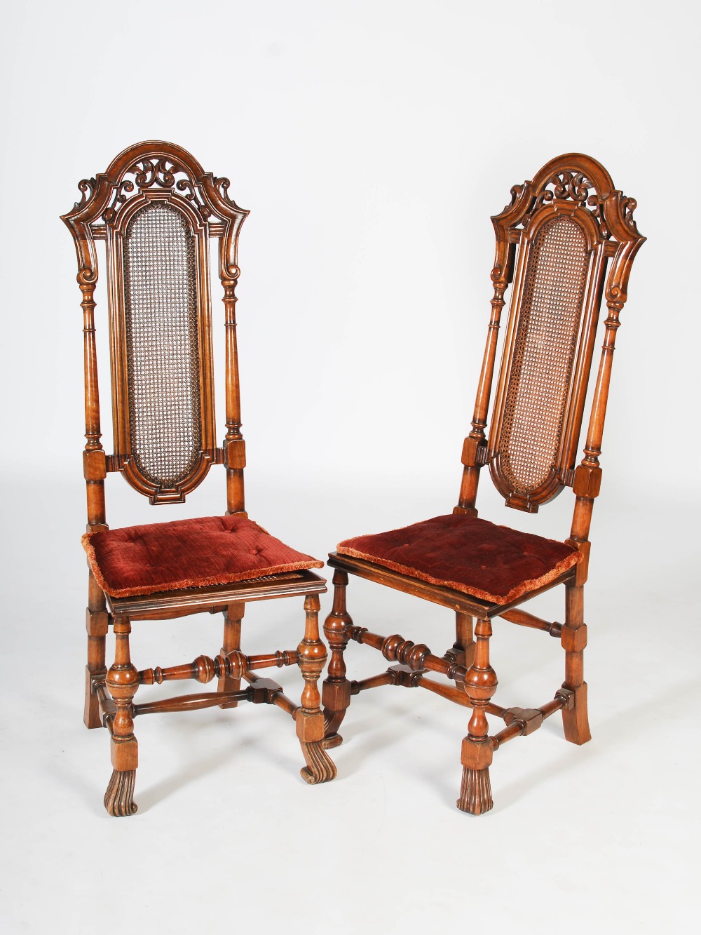 A pair of late 19th/early 20th century Continental walnut hall chairs, the upright backs with