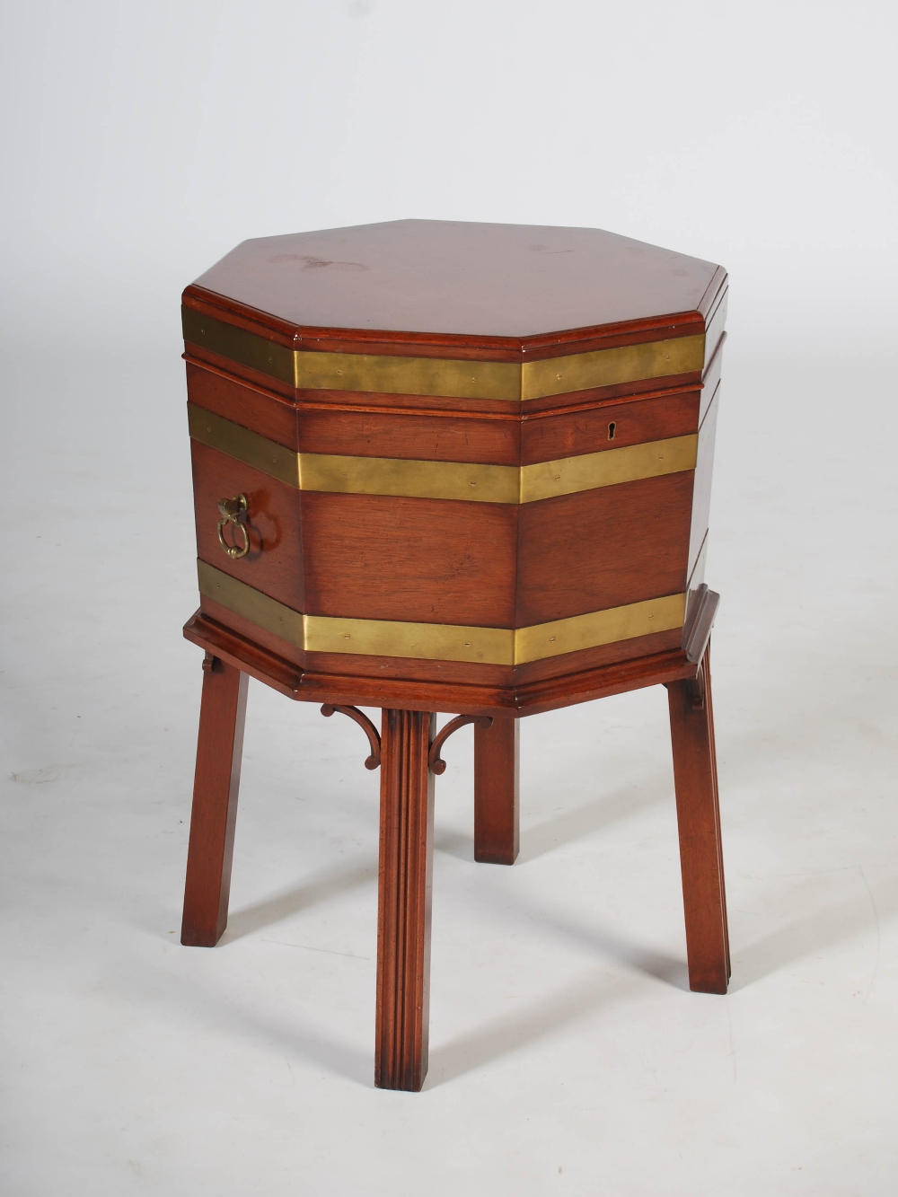 A reproduction George III mahogany and brass bound octagonal shaped wine cooler, the hinged cover