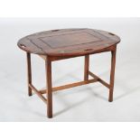 A 19th century mahogany butlers tray on associated stand, the oval shaped tray with hinged gallery