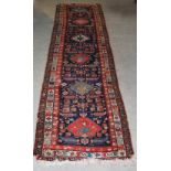 A Persian Kazak runner, late 19th/ early 20th century, the rectangular blue ground centred with