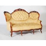 A Victorian mahogany sofa, the top rail carved and pierced with flowers and foliage above a back