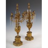 A pair of late 19th century ormolu five light candelabra, the urn shaped nozzles and foliate cast