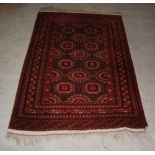 A Tekke rug, the chocolate brown ground decorated with octagonal shaped guls within repeating