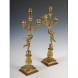 A pair of 19th century bronze Empire style four light candelabra, modelled with putti holding