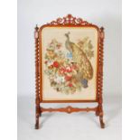 A large Victorian mahogany needlework embroidered fire screen, the rectangular needlework panel