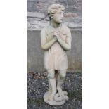 A 19th century carved stone figure of a boy, modelled standing with hands clasped, 132cm high