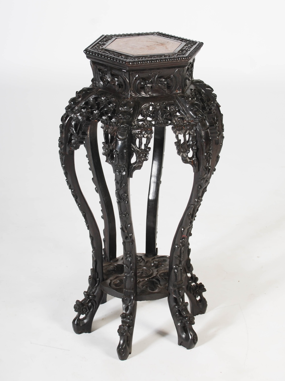 A Chinese dark wood hexagonal shaped jardiniere stand, Qing Dynasty, the shaped top with a mottled