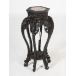 A Chinese dark wood hexagonal shaped jardiniere stand, Qing Dynasty, the shaped top with a mottled