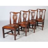 A set of four George III mahogany dining chairs, the shaped top rails above pierced scrolling and
