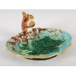 A 19th century George Jones Majolica nut dish, the leaf and foliate moulded dish set with a squirrel