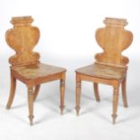 A pair of Victorian oak hall chairs, the gadroon carved top rail above a vase shaped back with