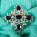 A 20th century white metal, sapphire and diamond set square open panel brooch, set with five oval