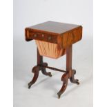 A Regency mahogany, rosewood and brass inlaid work table, the rectangular top with twin drop leaves,