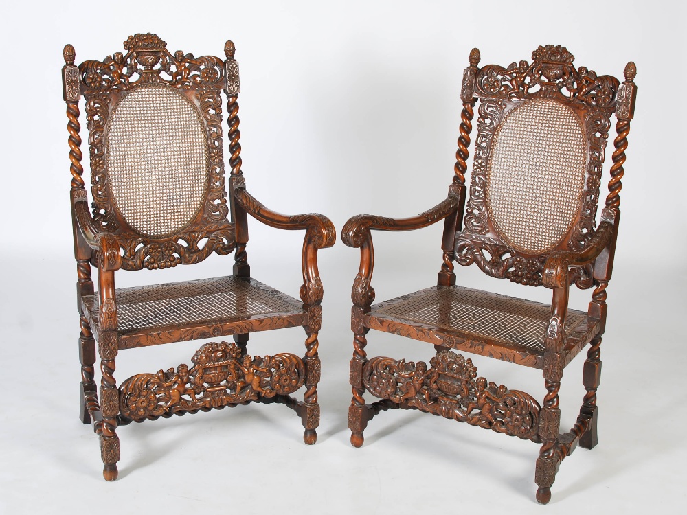 A pair of late 19th century Carolean style carved walnut armchairs, the top rails carved and pierced