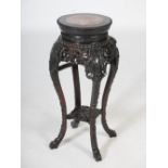 A Chinese dark wood jardiniere stand, Qing Dynasty, the circular top with a mottled red and white