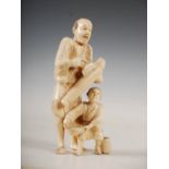 A Japanese ivory okimono of a parasol maker and boy, Meiji Period, 14.5cm high