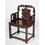 A Chinese dark wood armchair, Qing Dynasty, the scroll carved top rail centred with a bat above a