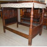 A 17th century style oak single four poster bed, the rectangular panelled top with foliate fringe,