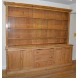 A late 19th/early 20th century pine country house kitchen dresser, the upper section with moulded