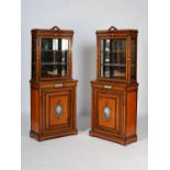 A pair of Victorian satinwood, ormolu and porcelain mounted display cabinets, the upper sections