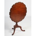 A George III mahogany occasional table, the hinged circular top with a pie-crust edge raised on a