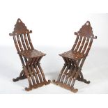 A pair of Middle Eastern style mother of pearl inlaid X-frame hall chairs, the scroll carved top