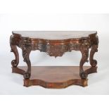 An impressive Chinese dark wood console table, Qing Dynasty, the serpentine shaped top with a