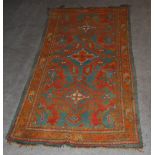 A Ushak rug, late 19th/ early 20th century, the green ground centred with three orange and red