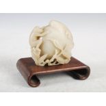 A Chinese jade carving of a peach, monkey and bat, on scroll carved wooden stand, jade 10cm high x