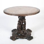 A Chinese dark wood centre table, Qing Dynasty, the circular top with a mottled red and white marble