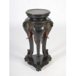 A late 19th/early 20th century ebonised and gilt metal mounted elephant head jardiniere, the