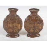 A pair of Japanese bronzed metal moon flasks, Meiji Period, decorated in relief with figures,