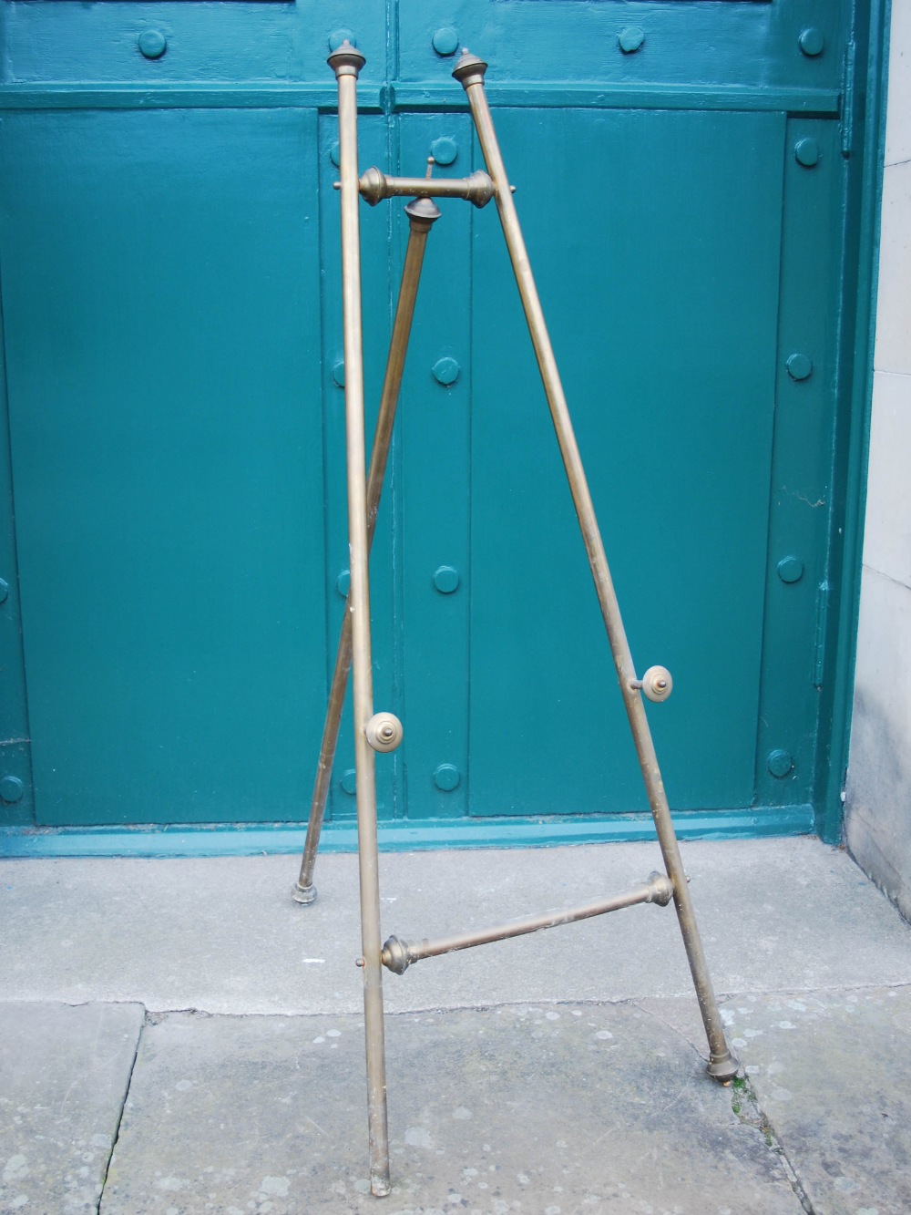 An early 20th century brass easel, 149cm high x 59cm wide.