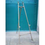 An early 20th century brass easel, 149cm high x 59cm wide.